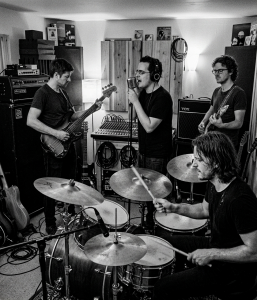 Black and white photograph of Eventstellar members Nevan Lochlann, Eoin Belfield, Jesse Rómlárson and Jon Gilmour performing together during an early recording session at Nevan's studio in Bray, County Wicklow, Ireland in 2017