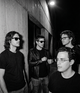 Black and white photograph of Nevan Lochlann, Jesse Rómlárson, J.J. Gilmour and Eoin Belfield outside University College Dublin during an early Eventstellar gathering in 2017