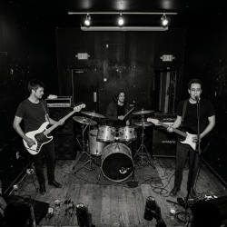 Nevan Lochlann, Eoin Belfield and Jesse Rómlárson performing an early Sojourner show in front of a small crowd in Ireland