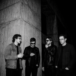 Black and white photograph of J.J. Gilmour, Eoin Belfield, Nevan Lochlann and Jesse Rómlárson outside University College Dublin following an early Eventstellar performance in 2017